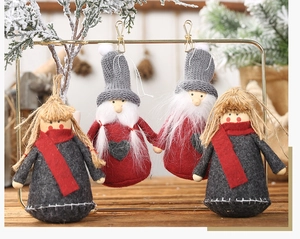 Detailed view of four felt Christmas elf hanging ornaments with knit details and heart patches