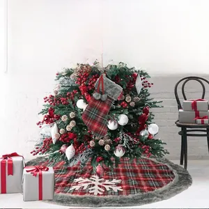 Detail of red plaid Christmas stocking and tree skirt with faux fur trim in festive setting
