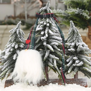 Gnome de Noël à carreaux avec cœur rouge et longue barbe blanche dans un décor de neige