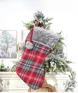 Detail of red and gray plaid Christmas stocking with faux fur trim on a holiday tree