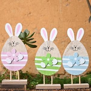 Detailed view of three pastel wooden Easter bunny egg ornaments on a stable base