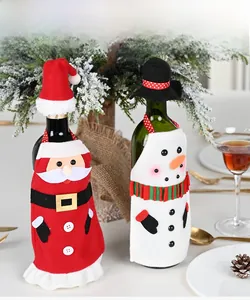 Detailed view of Santa and snowman wine bottle covers on a decorated Christmas table