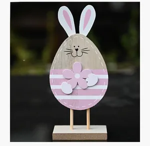 Close-up of Easter bunny wooden ornament with egg-shaped body and pink flower detail