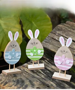 Detailed view of three Easter wooden bunny ornaments in pink, green, and blue on wood