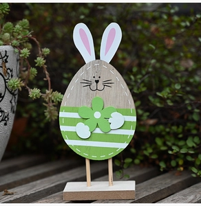 Detailed view of a wooden Easter bunny decoration with green stripes on a rustic wood bench
