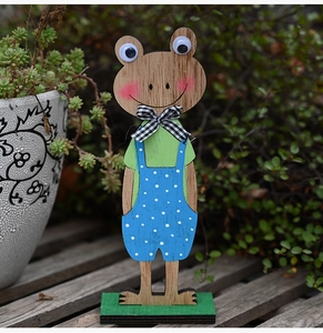 Detail van houten paaskikker met natuurlijke nerf en blauwe tuinbroek met witte stippen