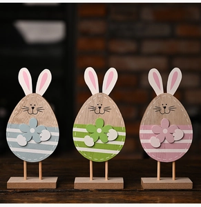 Detailed view of three pastel wooden bunny figurines on a rustic wooden base