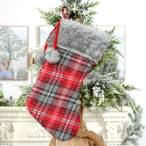 Classic red and black plaid Christmas stocking with grey faux fur trim and pom-poms