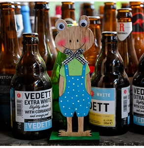 Detail van houten kikkerbeeldje met polkadot broek en een geruite vlinderdasje