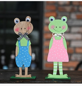 Detail van rustieke houten Pasen kikkerfiguren met stoffen strikken op groene voet
