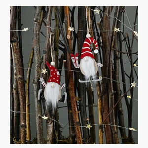 Detail of wooden Christmas gnome ornaments with white faux fur beards on rustic branches