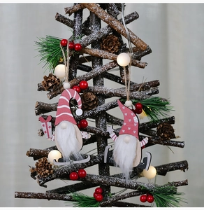 Detail of wooden gnome ornaments with plush beards hanging on a festive Christmas tree