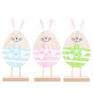 Three colorful wooden Easter bunny figures on wooden bases in blue, pink and green colors