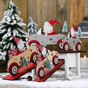 Close-up of wooden Santa Claus cars with miniature trees and stars in a snowy scene