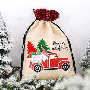 Close-up of burlap Christmas gift bag with red truck and forest gnome prints