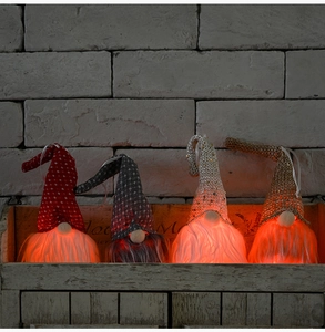 Détail de quatre gnomes de Noël lumineux avec éclairage LED et chapeaux tricotés