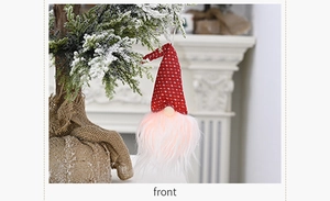 Gnome de Noël lumineux suspendu avec bonnet rouge à pois sur une branche de sapin