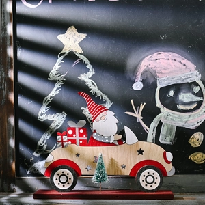 Wooden Santa Claus car ornament with small pine tree on a red base for Christmas decor