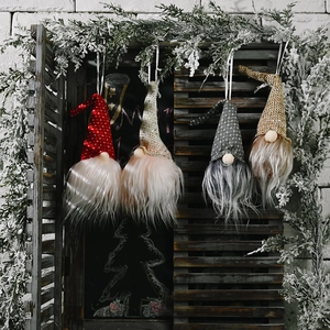 Lot de quatre gnomes de Noël festifs à LED suspendus à une fenêtre en bois rustique