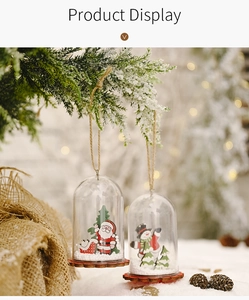Detail of Christmas hanging ornaments with wooden base and snow inside clear dome