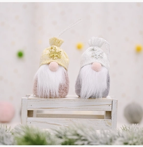 Close-up of plush Christmas gnomes with snowflake sequins and long white beards on wood