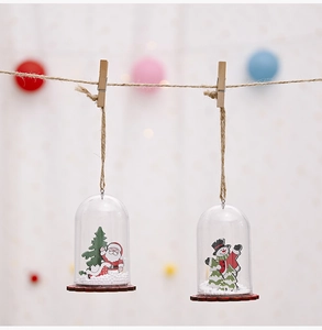 Detail of Christmas hanging ornaments with wooden base and fake snow inside transparent dome