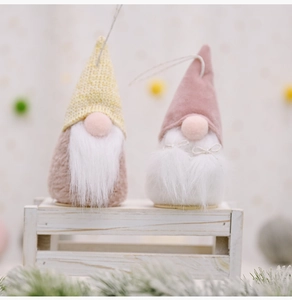 Detail of two knit Christmas gnomes with long white beards and festive hanging strings