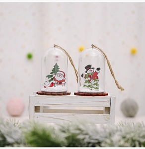 Close-up of Christmas ornaments with Santa and Snowman in clear domes on wooden base