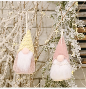 Detail of plush Christmas gnome ornaments with knit hats and warm festive lighting