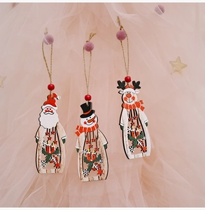 Detailed view of three hollow wood Christmas ornaments with Santa, Snowman and Reindeer