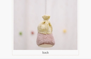 Close-up of yellow knit top and pink plush body of a Christmas gnome hanging ornament
