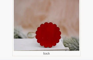 Rear view of a red scalloped wooden Christmas ornament with natural jute hanging string