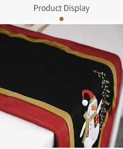 Detail of Christmas table runner with plush black fabric and festive snowman embroidery
