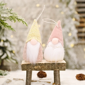 Set of two Christmas faceless gnome ornaments with knitted hats on snowy wooden bench