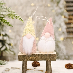 Handmade Christmas gnome hanging ornaments with knitted hats on a rustic wooden stool