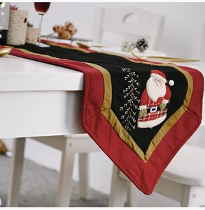 Close-up of a festive Christmas table runner featuring an embroidered Santa Claus design