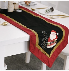 Detail of red and black Christmas table runner with festive Santa Claus embroidery