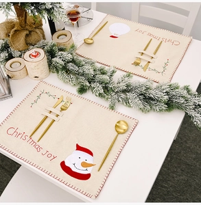 Détail de sets de table de Noël en toile avec Père Noël et poches pour couverts
