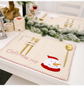Détail du set de table de Noël en lin avec appliqué bonhomme de neige et porte-couverts