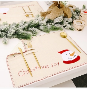 Détail de set de table de Noël en lin avec broderie bonhomme de neige et porte-couverts