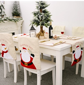 Détail de housses de chaises et chemin de table de Noël avec broderies Père Noël et Bonhomme