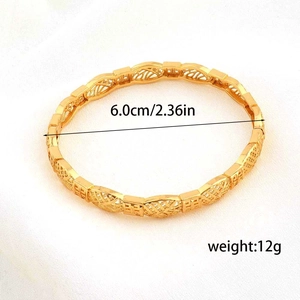 Dettaglio di un bracciale placcato oro 24K con texture cava e diametro di 6 cm