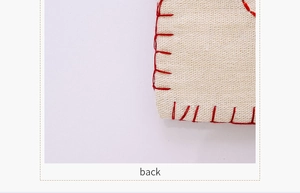 Vue macro du dos du set de table en lin beige avec coutures rouges et texture rustique