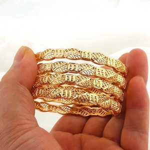 Dettaglio dei bracciali traforati placcati oro 24K con il carattere Fu cinese
