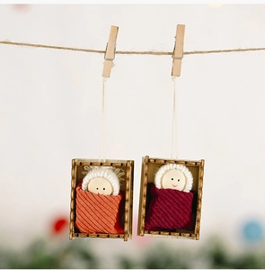 Macro detail of handmade Christmas wooden dolls with knitted hats hanging on a rustic jute rope
