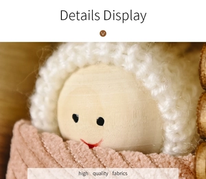 Close-up of wooden Christmas doll with white knit hat and soft pink fabric texture