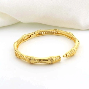 Close-up of 18K gold plated bamboo bangle with intricate hollow lattice and rhinestones