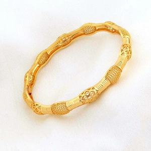 Bracciale rigido dorato in stile mediorientale con intricati motivi geometrici traforati