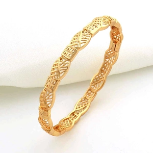 Dettaglio di un bracciale placcato oro 24 carati con motivi a fragola e texture geometriche