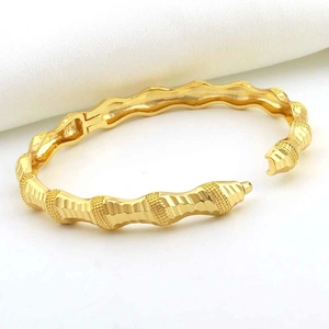 Macro-detail van gouden bamboe armband met getextureerde segmenten en gepolijste afwerking